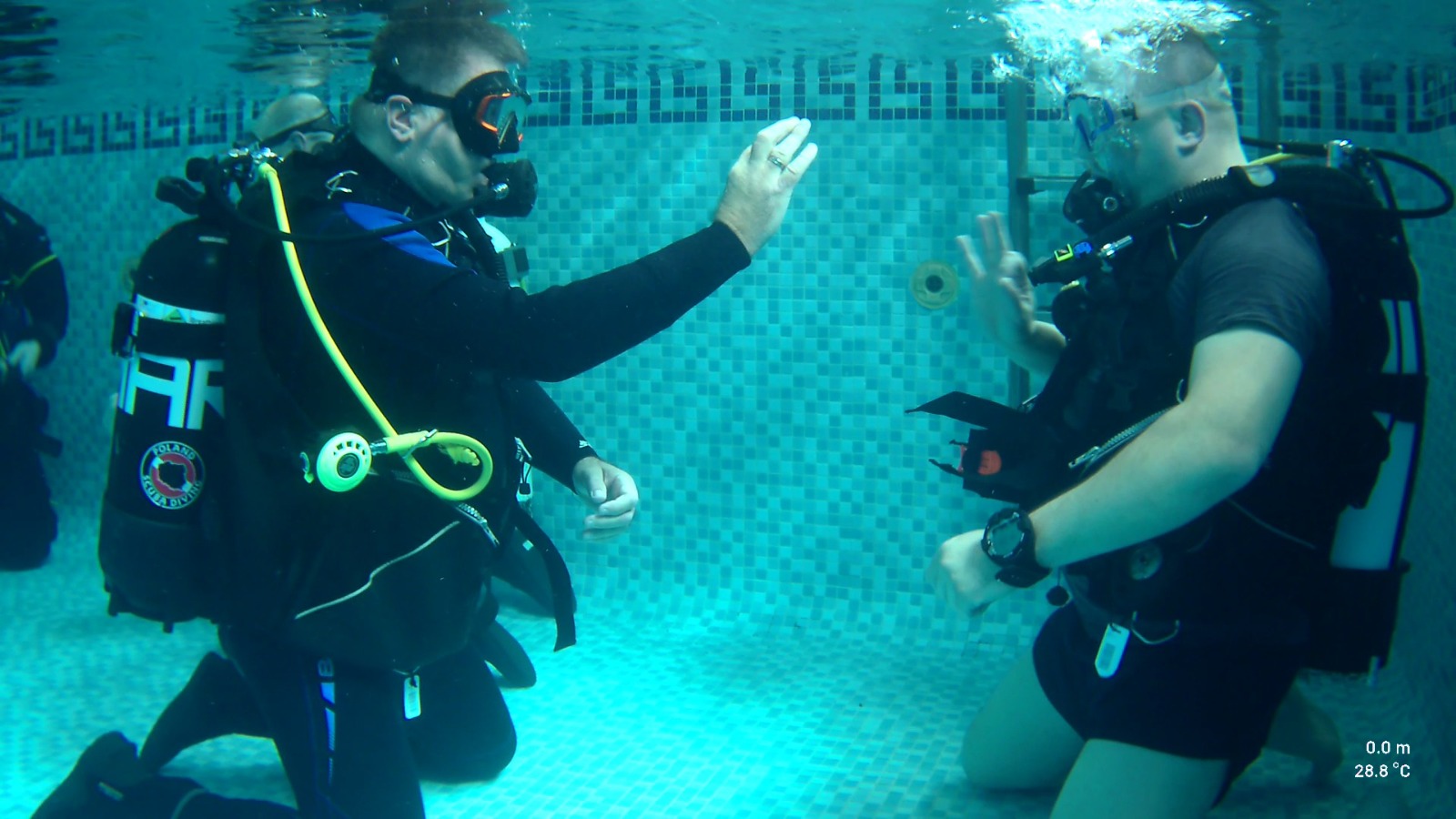 Instructor and student exchanging the OK sign in the training pool