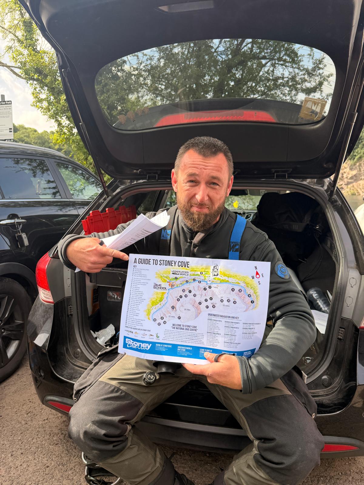 Diver holding the Stoney Cove site map before a dive